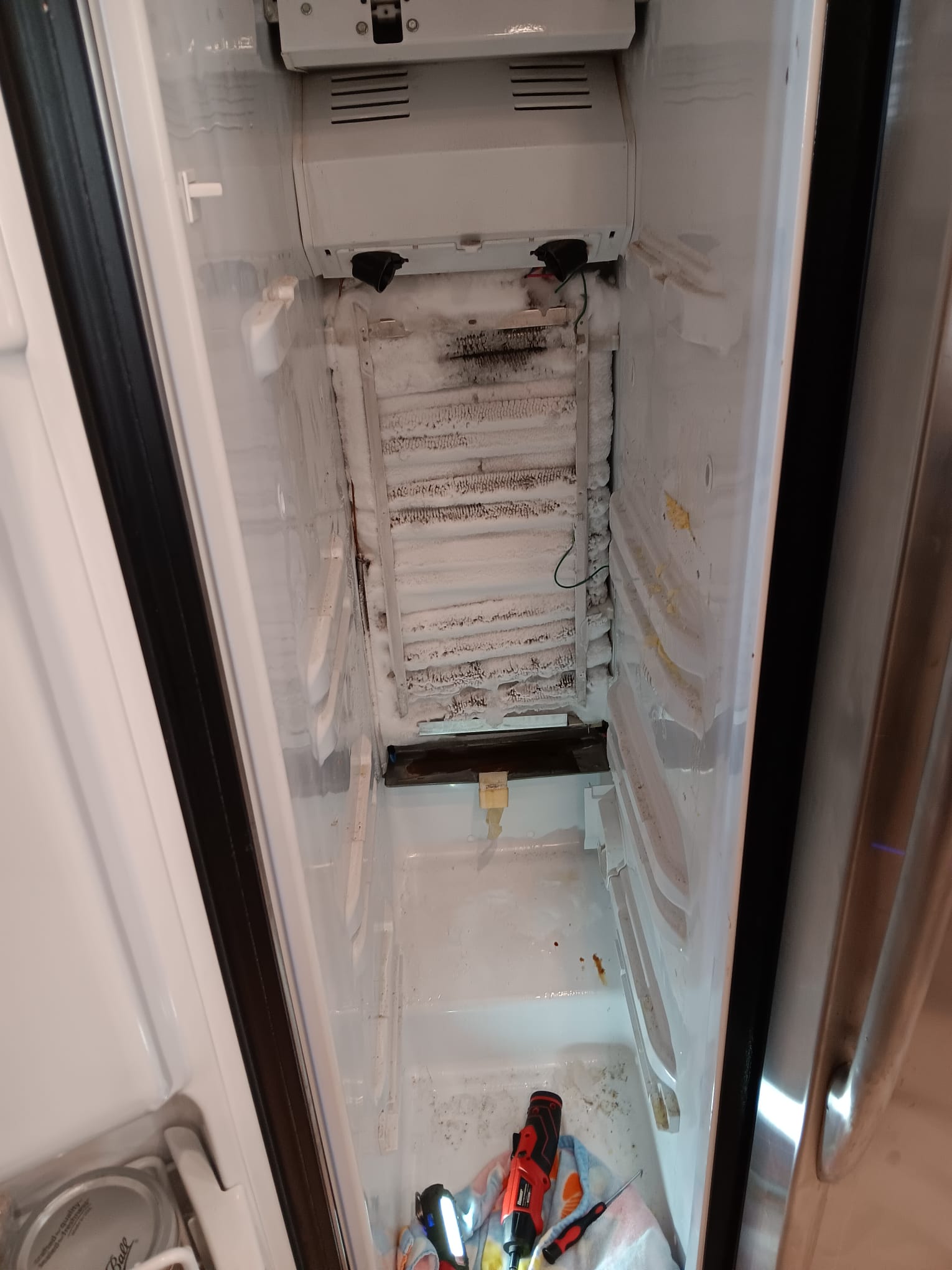 Frosted evaporator coils and freezer compartment during diagnosis of the GE refrigerator's defrost system