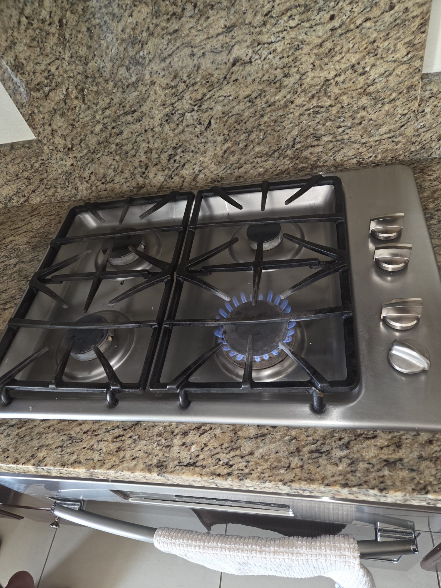 GE gas cooktop during diagnosis with a single burner lit