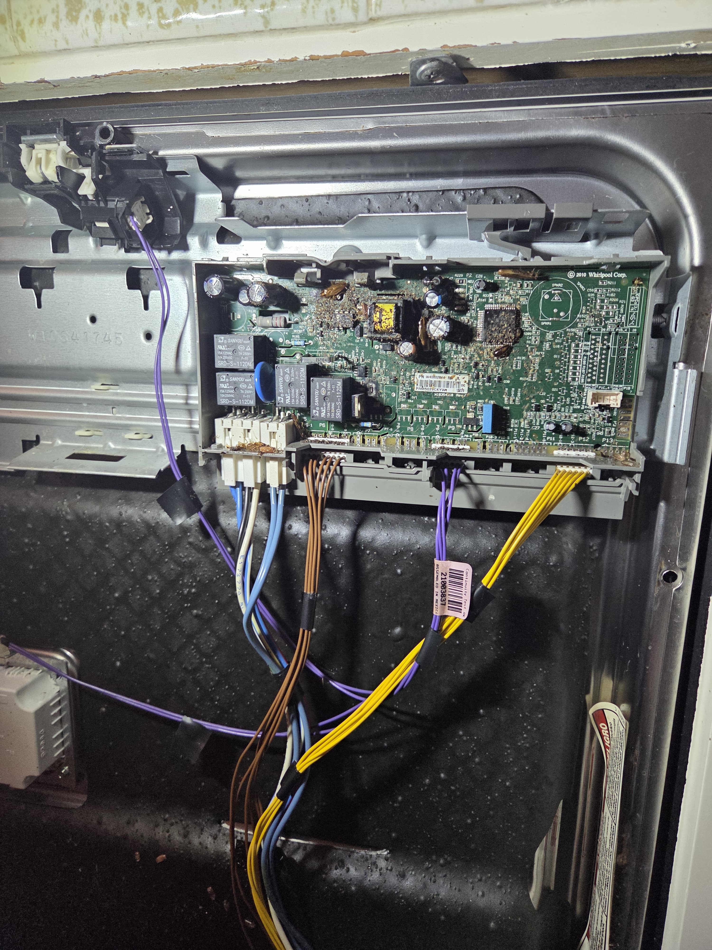 Kenmore dishwasher door opened to reveal the control board damaged by pest debris