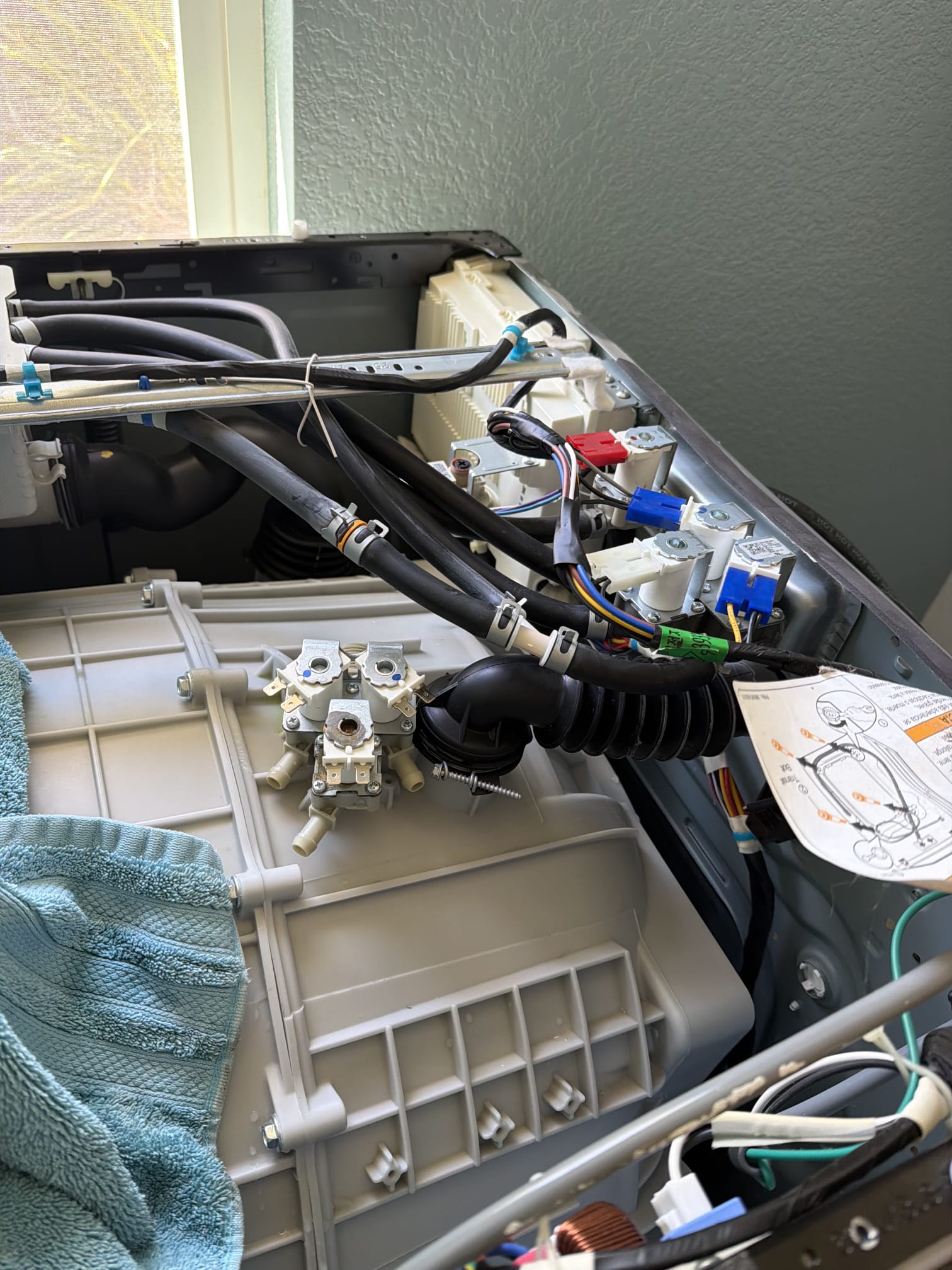 New water inlet valve installed and wiring reconnected inside the Kenmore Elite washer's top panel