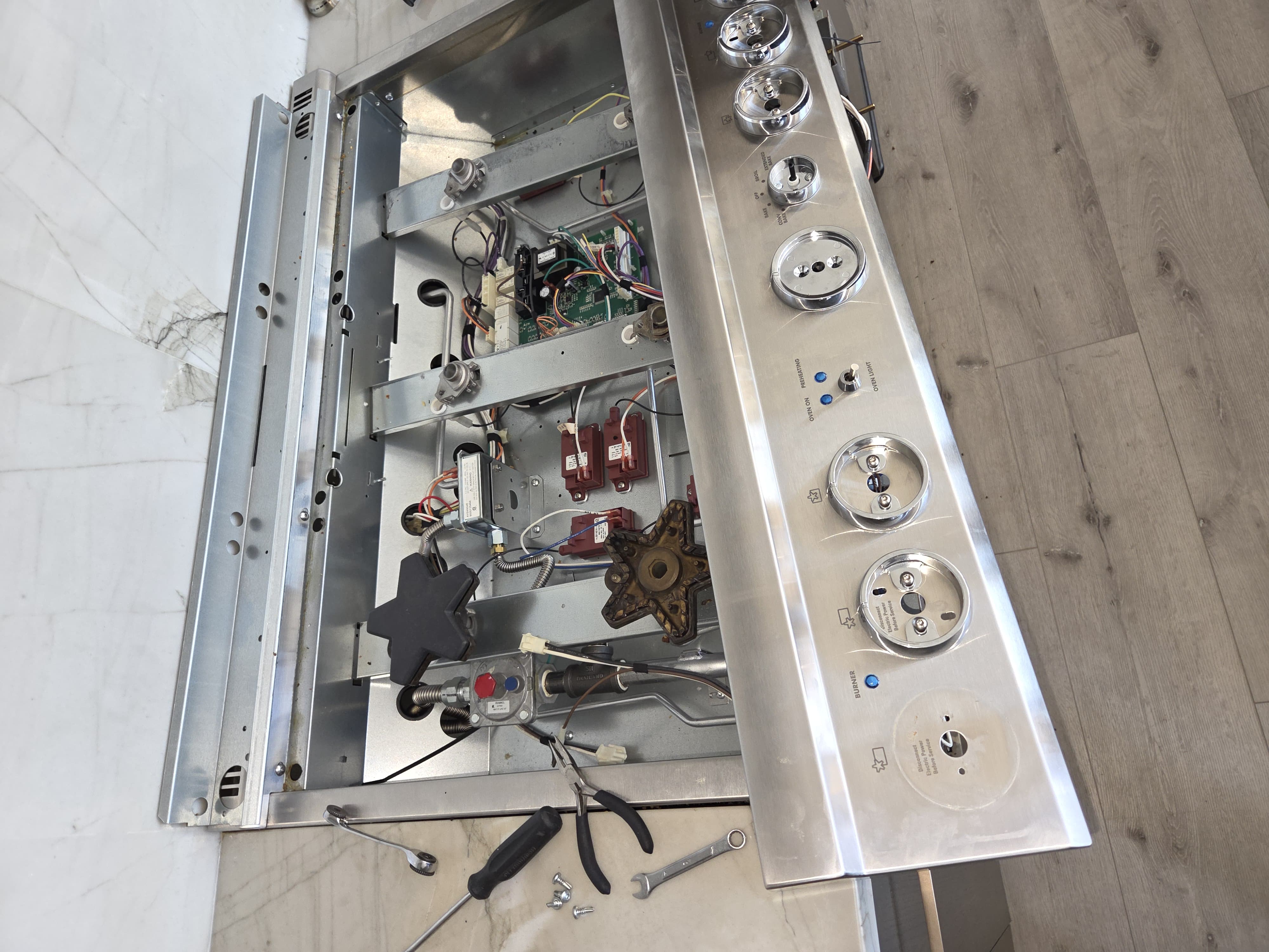Thermador range with the control panel removed, exposing the spark modules and internal wiring