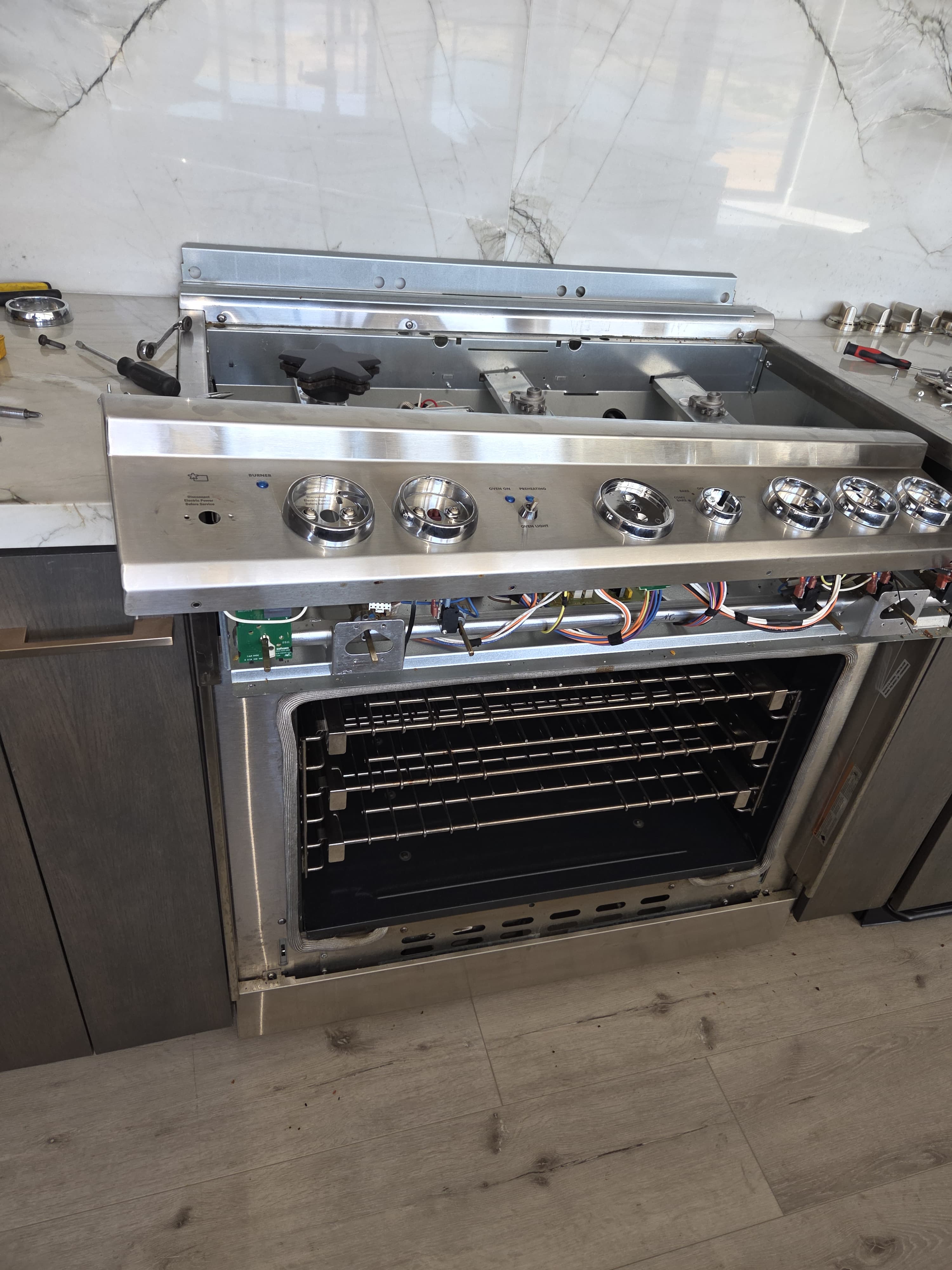 Thermador range opened up during the repair with the cooktop raised and wiring accessible