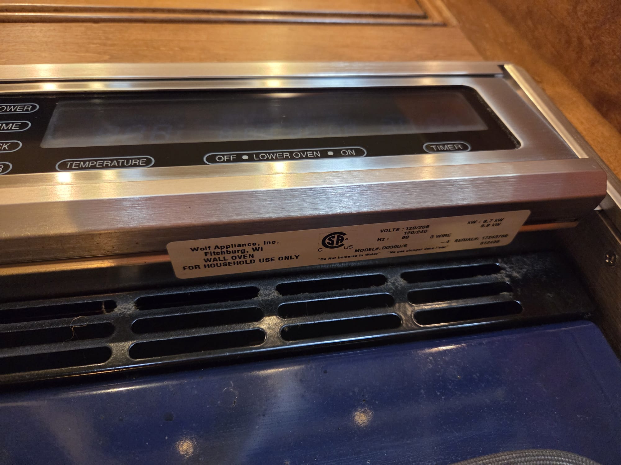 Wolf wall oven control panel and model tag exposed during diagnosis of the unresponsive controls