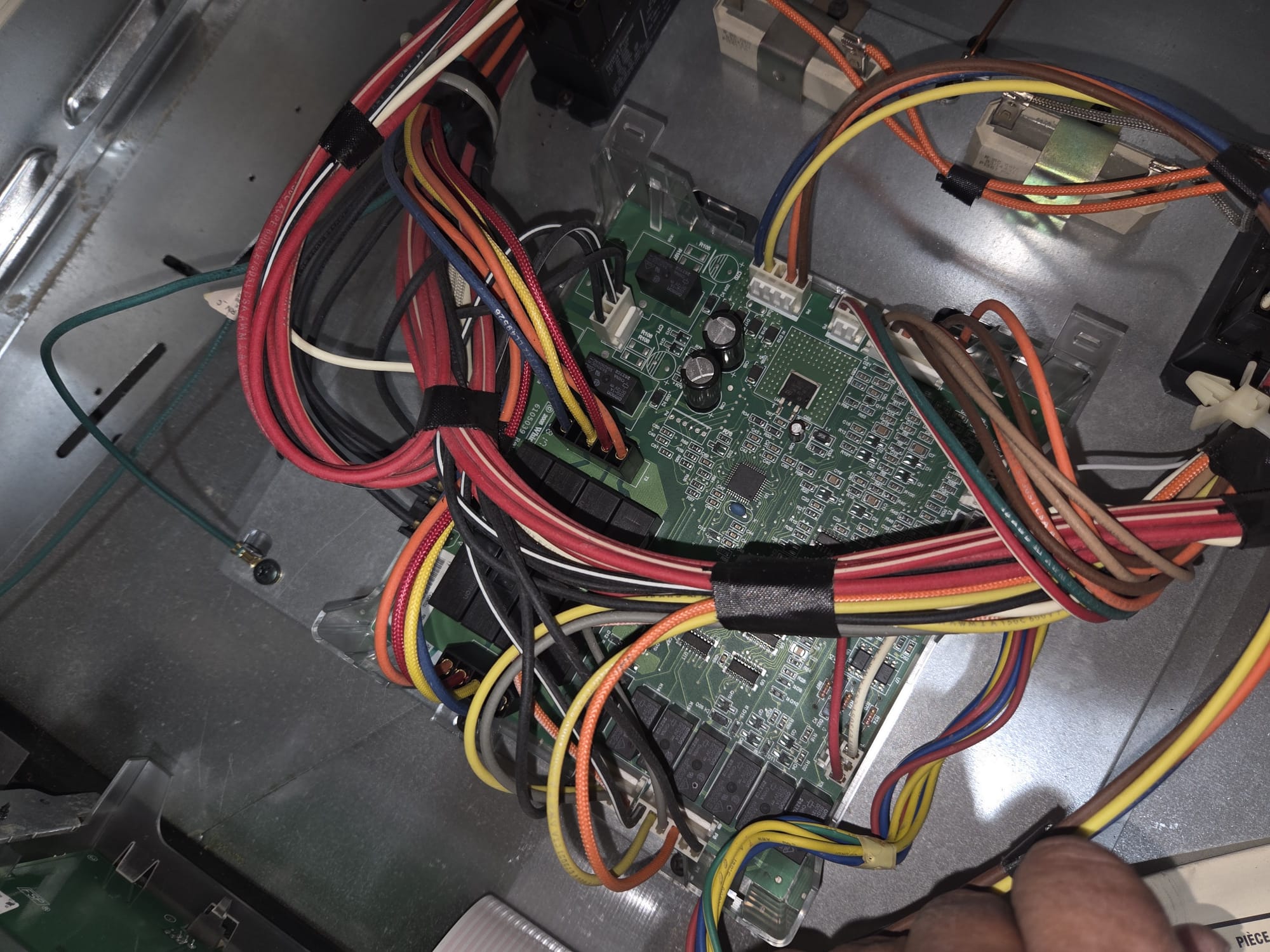 Failed Wolf wall oven main control board with its extensive wiring harness exposed