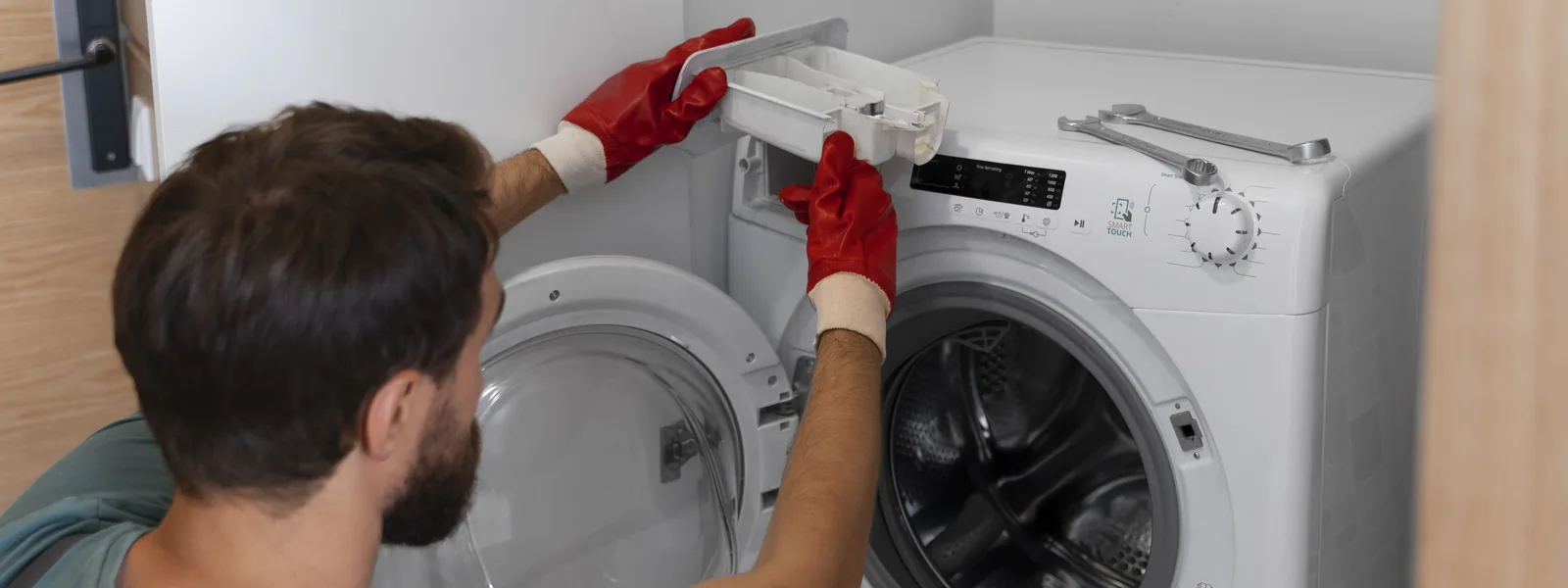 Rapid Solutions technician removing the detergent drawer from a front-load washing machine